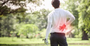 man on golf course experiencing back pain