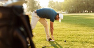 man taking a break to stretch on golf course