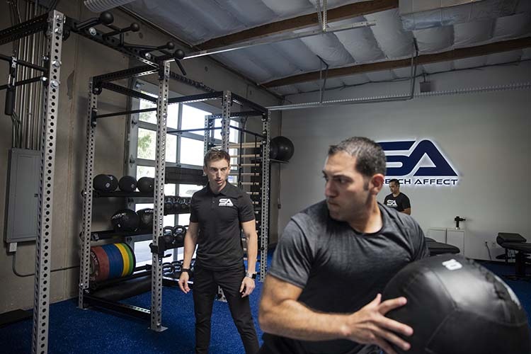 stretch professional monitors form of client in rotational medicine ball exercise