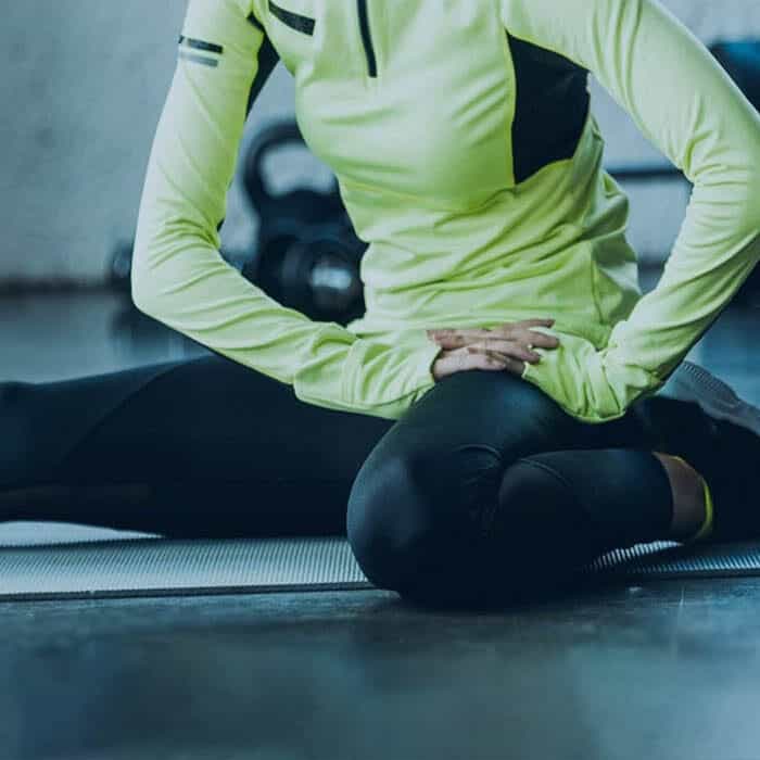 person in running attire performing seated hamstring stretch